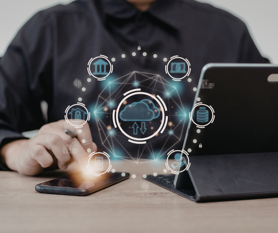 Professional using a laptop and mobile device with a digital cloud interface overlay, illustrating cloud computing, AI-enabled data infrastructure, secure enterprise systems, and intelligent connectivity across modern business environments.