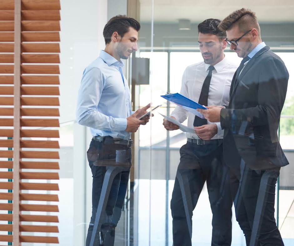 Corporate professionals analysing reports and business data during a strategic meeting. The image represents enterprise decision-making, revenue planning, performance optimisation, and data-driven collaboration in a modern B2B environment.
