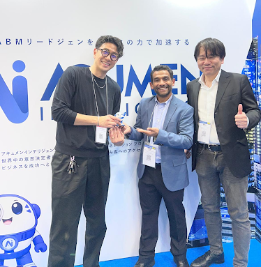 Acumen Intelligence leadership team interacting with a client at Tokyo Big Sight during Japan IT Week 2026, showcasing the Acumori mascot and strengthening enterprise partnerships.