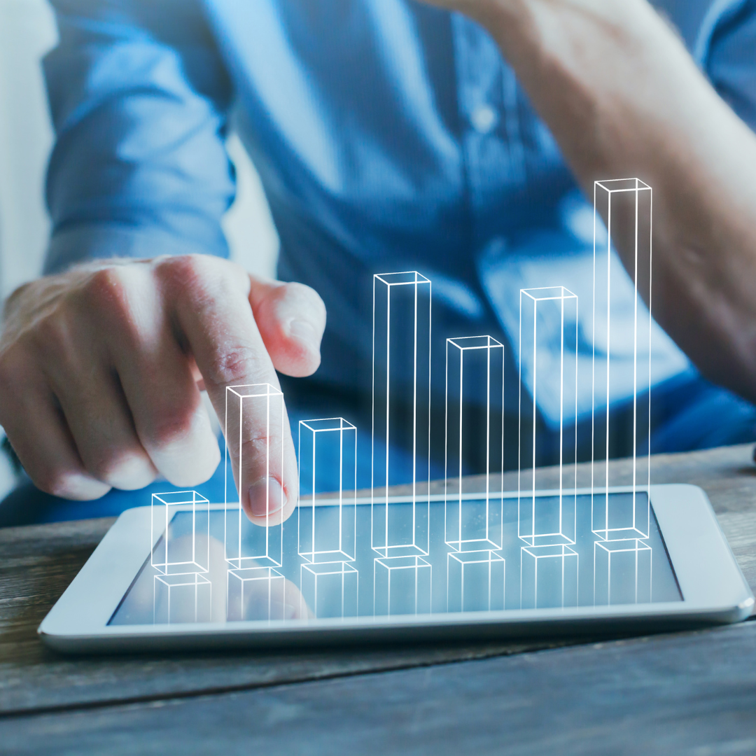 A marketing professional interacts with a digital bar chart on a tablet, representing data-driven performance measurement, campaign analysis, pipeline intelligence and revenue growth.